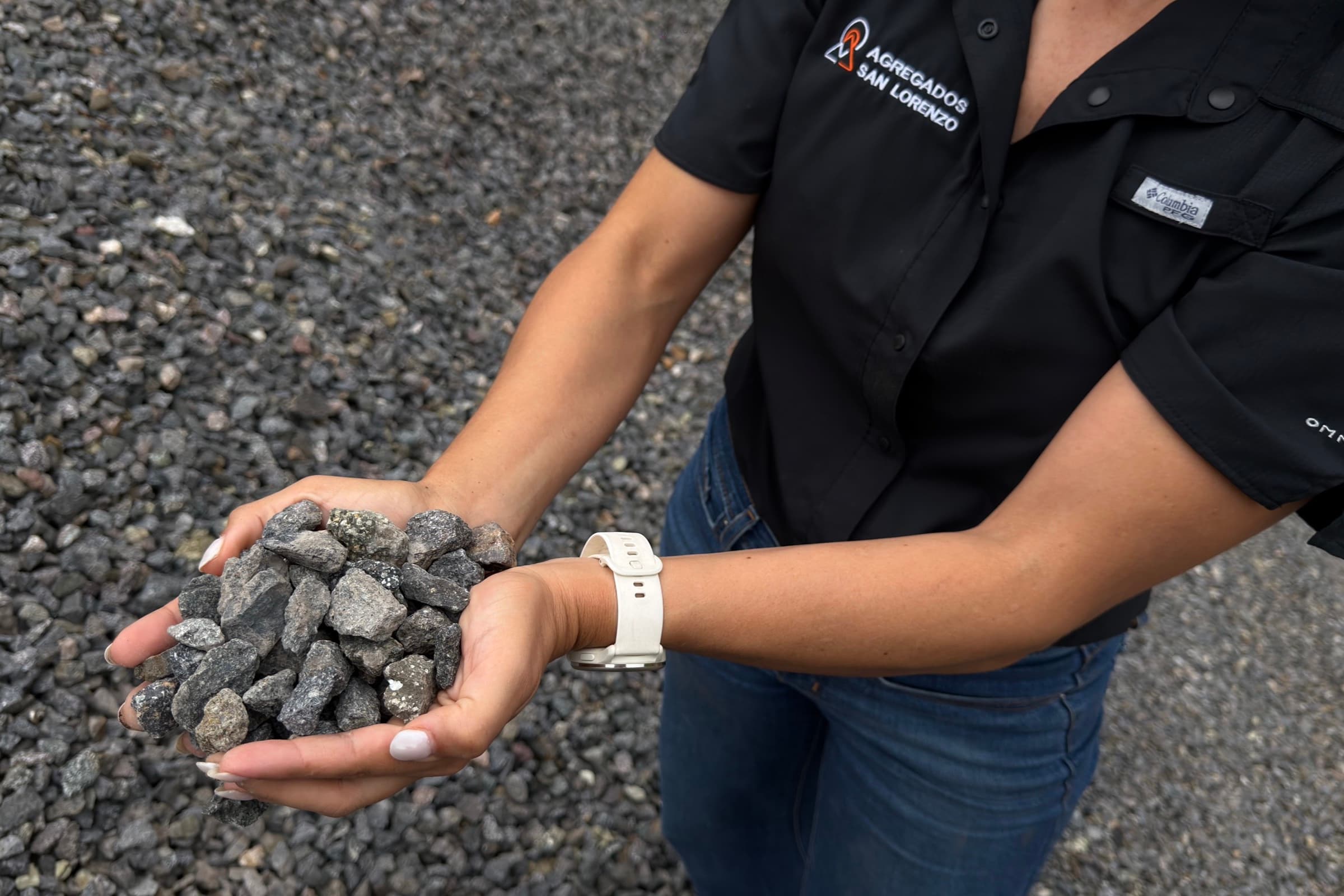 Colaboradora de Agregados San Lorenzo sosteniendo piedra recién triturada